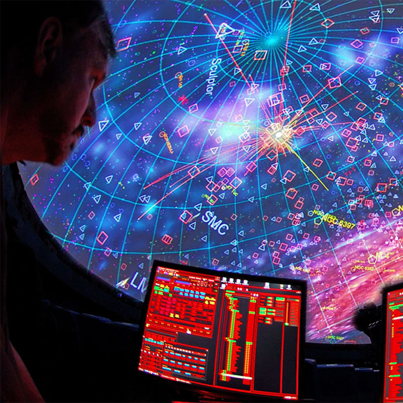 An astronomer with dual screen monitors studies data
