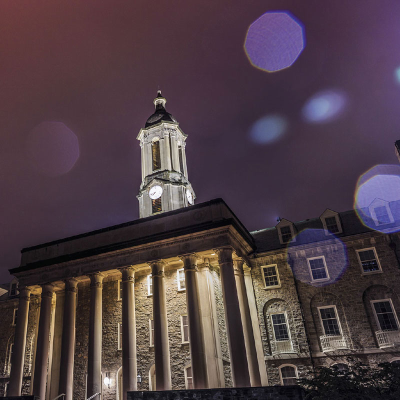 Penn State's administration building, Old Main, lit up at night.